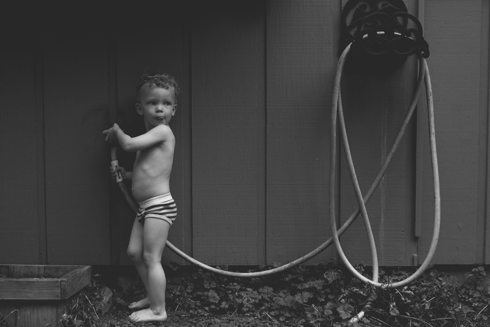 documentary family photography boy with sprinkler