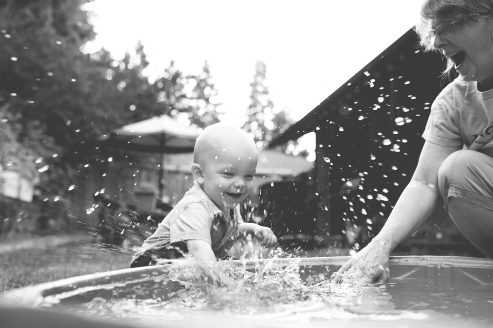 documentary family photography - baby splashing with grandma