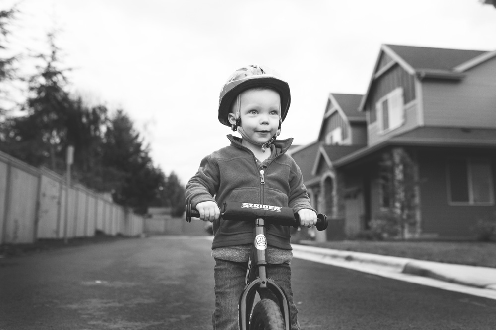documentary family photography - toddler on a balance bike with helmet