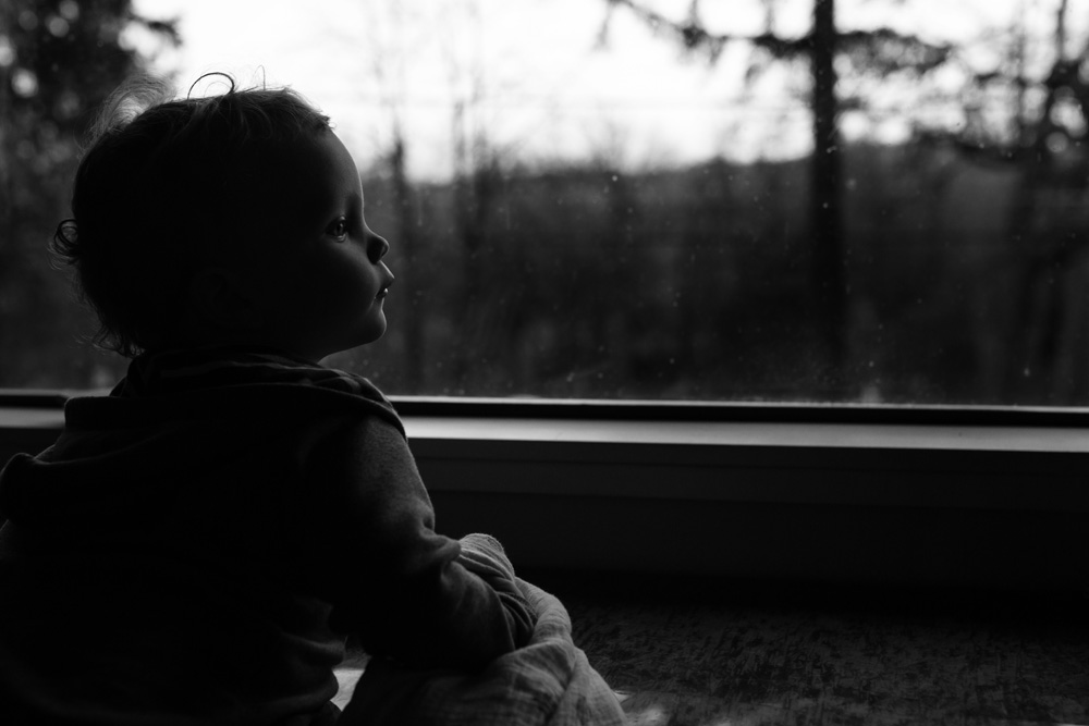 documentary family photography - toddler gazing out the window