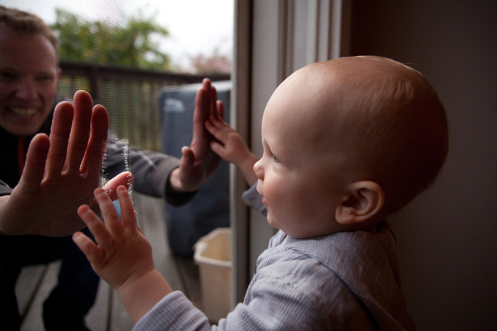 documentary family photography - baby looking out the window